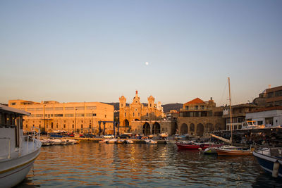 Boats moored at canal against buildings in city