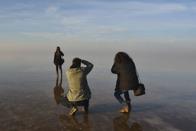 Rear view of people walking on beach