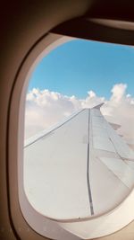 Close-up of airplane window against sky