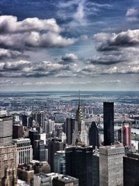 View of cityscape against cloudy sky