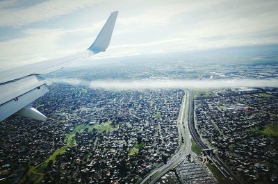 Cropped image of airplane wing over landscape