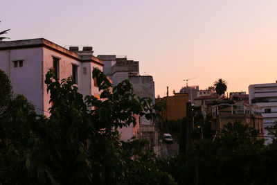 Residential buildings against sky at sunset