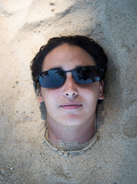 Portrait of woman buried in sand