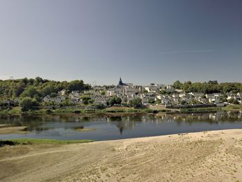 River by buildings against clear sky