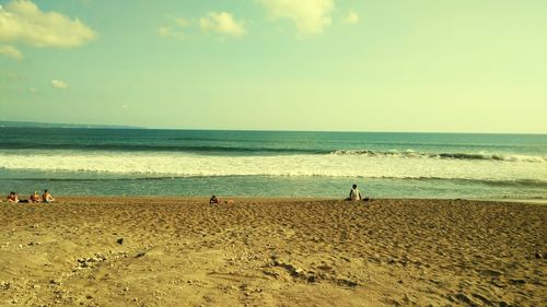 People standing on beach against sky