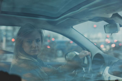 Portrait of young woman in car