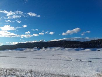 Scenic view of snowcapped mountains against blue sky