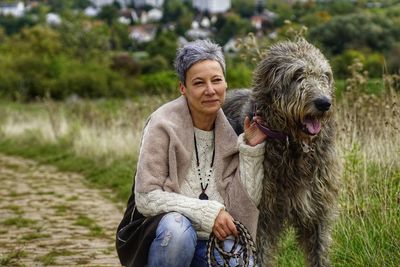 Mature woman kneeling by dog