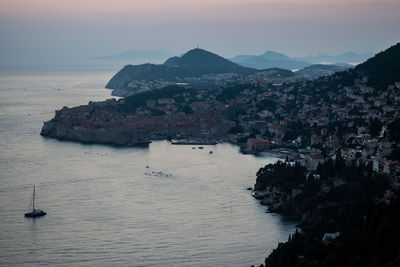 High angle view of city by sea during sunset