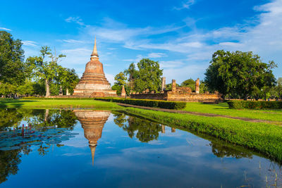 Reflection of temple on building against sky