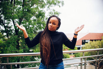 Portrait of woman with braided hair standing by railing