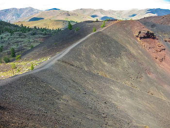 Road by mountains against sky