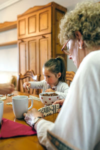 Mother and daughter sitting on table