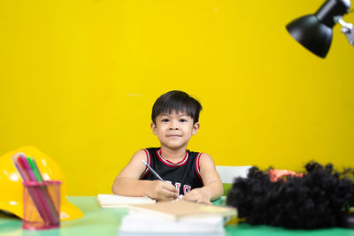 Portrait of boy sitting on table