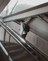 Low angle view of man standing on escalator