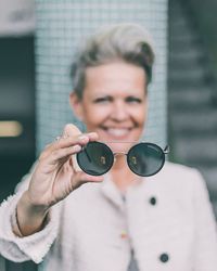 Portrait of smiling man holding sunglasses