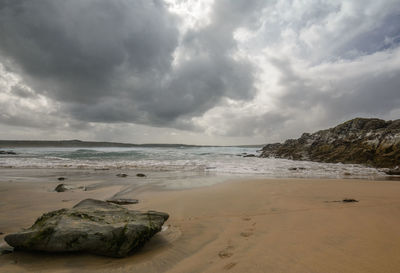 Scenic view of beach and cloudy sky