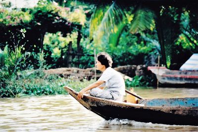 Man sitting on boat in lake