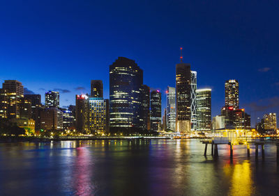 Reflection of illuminated buildings in calm river