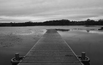 Pier over lake against sky