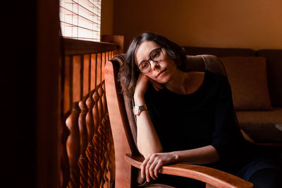 A portrait of a thoughtful girl sitting in a chair close to the window