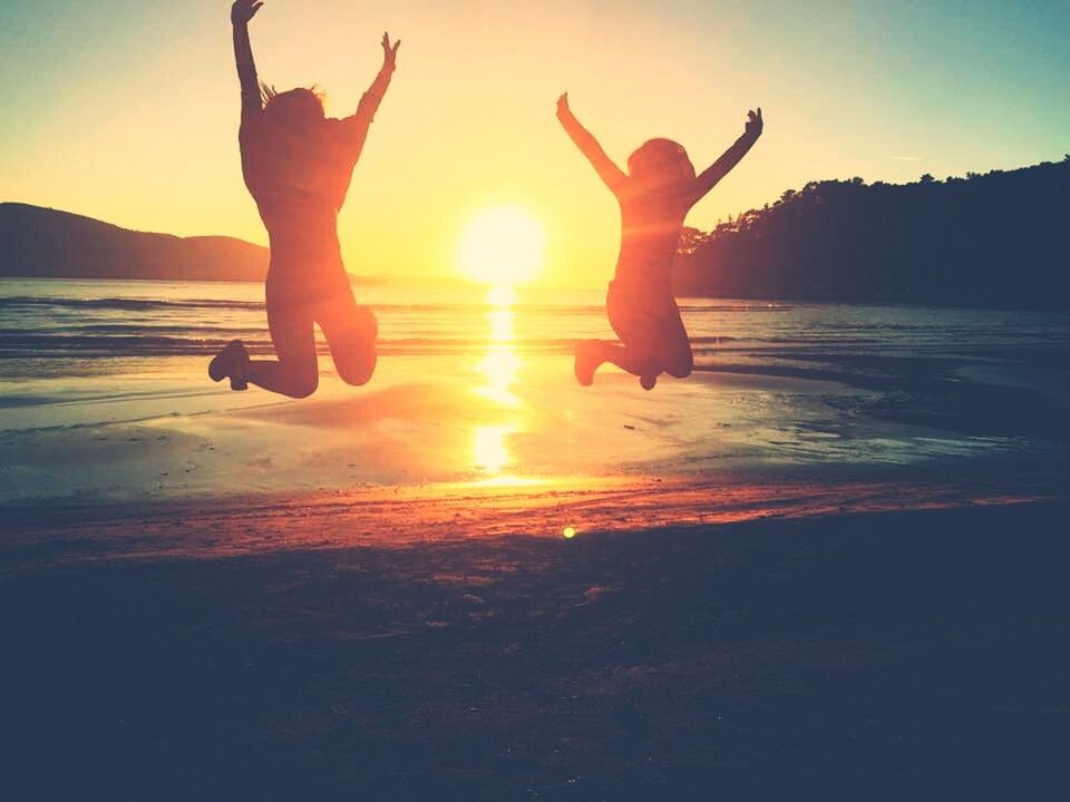 leisure activity, lifestyles, sunset, beach, sun, sea, enjoyment, fun, jumping, vacations, silhouette, water, mid-air, carefree, orange color, full length, sky, shore