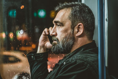 People, lifestyle, travel and public transport. attractive man talking on the phone in public bus.