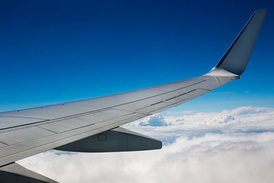 Cropped image of aircraft wing flying in sky