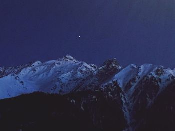 Scenic view of snowcapped mountains against sky at night