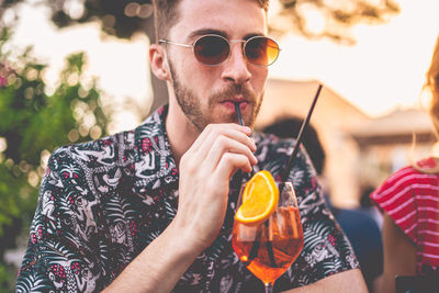 Portrait of young man drinking glasses