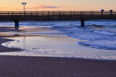 Pier over sea against sky during sunset