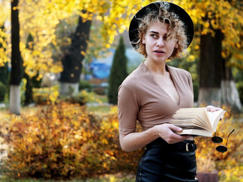 Portrait of young woman standing in park