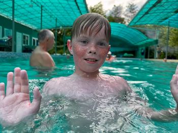 Portrait of shirtless boy swimming in pool