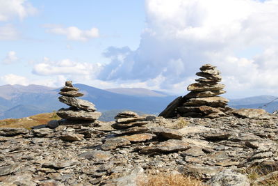 Stack of rocks on mountain against sky