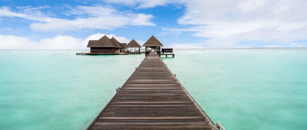 Wooden pier leading towards water bungalows