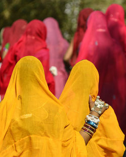 Rear view of woman in yellow sari on sunny day