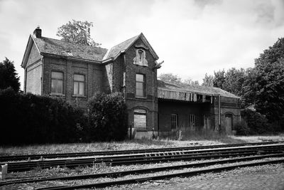 Railroad tracks by building against sky