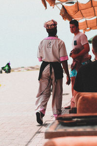 Men standing on beach against sky