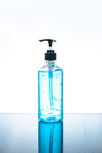 Close-up of glass bottle on table against white background