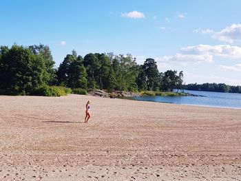 Woman on beach against sky