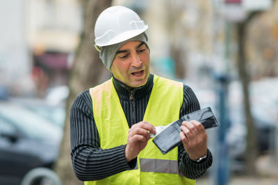 Engineer in reflective clothing looking at wallet