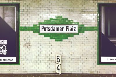 Signs on tiled wall at subway station