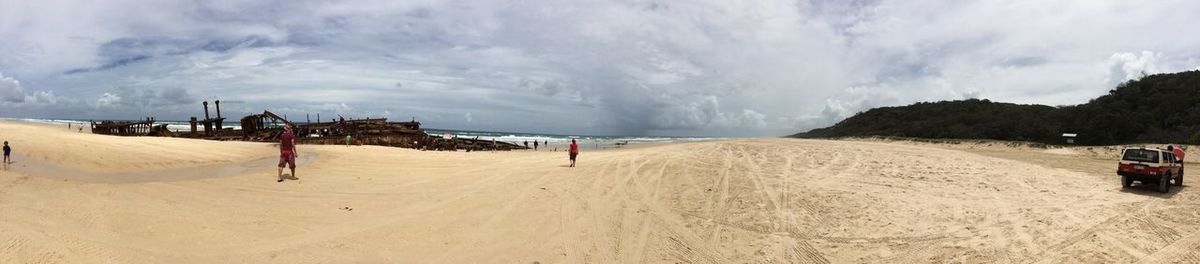 Scenic view of beach against cloudy sky