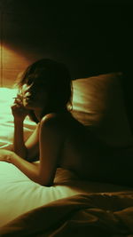 Side view of woman relaxing on bed