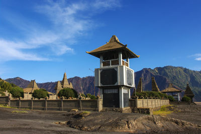 Built structure by mountains against blue sky luhur poten temple bromo tengger semeru national parc