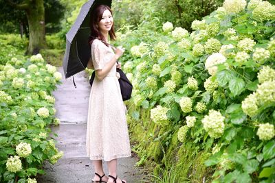 Woman standing by plants