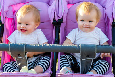 Two beautiful little twin babies, portrait in a baby carriage