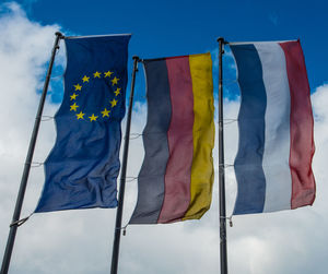 Low angle view of flag against blue sky