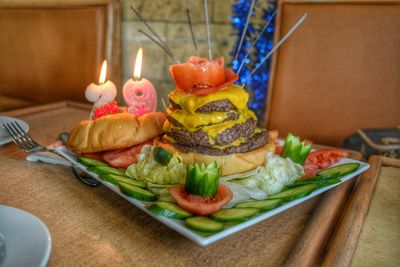 Hamburger with vegetables served in plate
