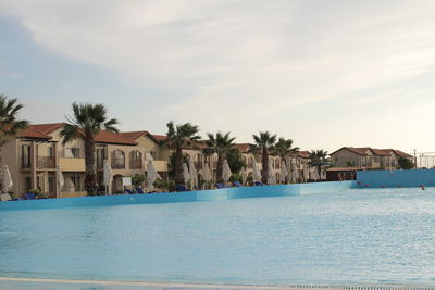 View of swimming pool by sea against sky